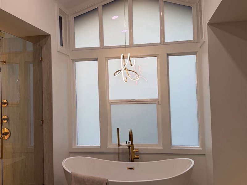 Baño con ventanas esmeriladas sobre la tina
